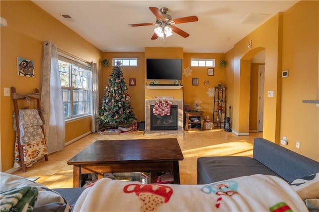 living room with a fireplace and ceiling fan