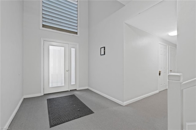 foyer featuring carpet flooring and a towering ceiling