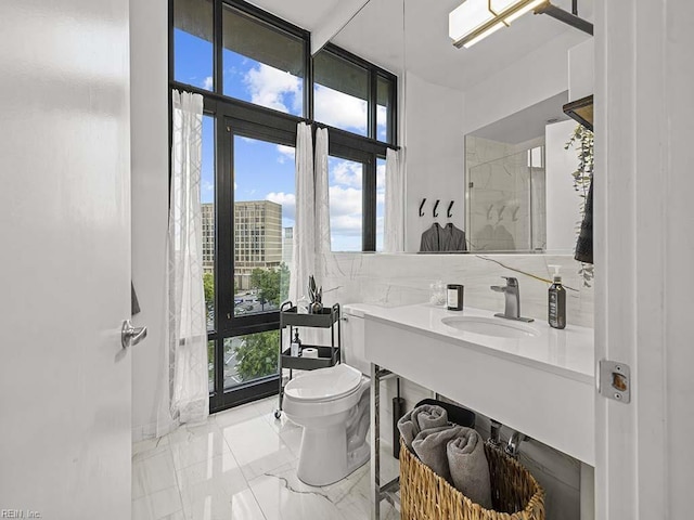 bathroom with decorative backsplash, toilet, and sink