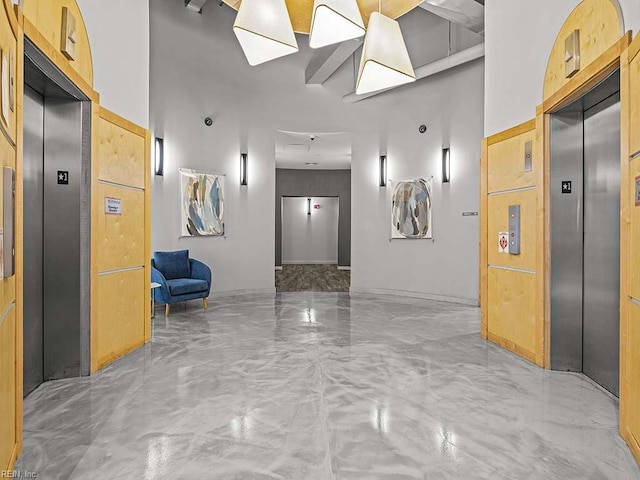 hall featuring concrete flooring and elevator