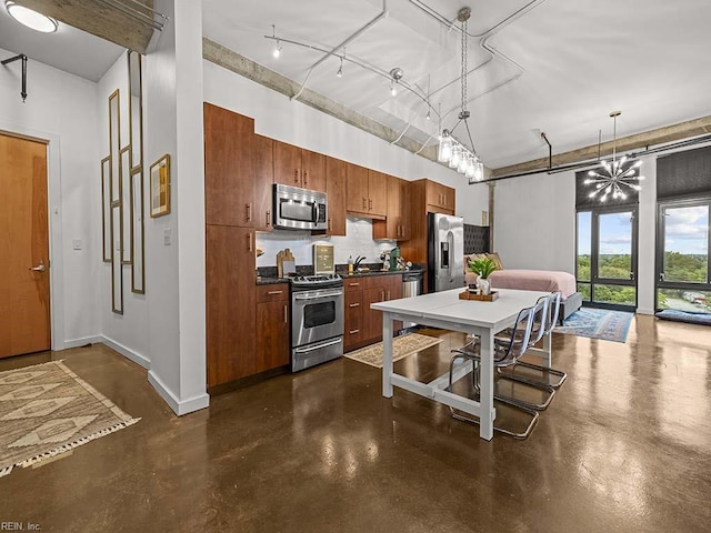 kitchen featuring decorative light fixtures, sink, stainless steel appliances, and a high ceiling