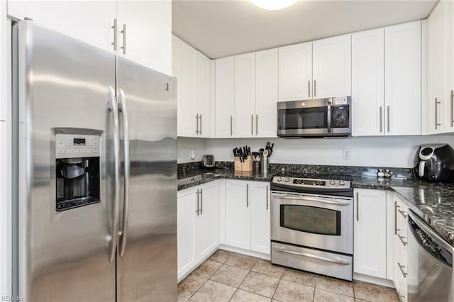 kitchen with white cabinets, appliances with stainless steel finishes, and dark stone counters