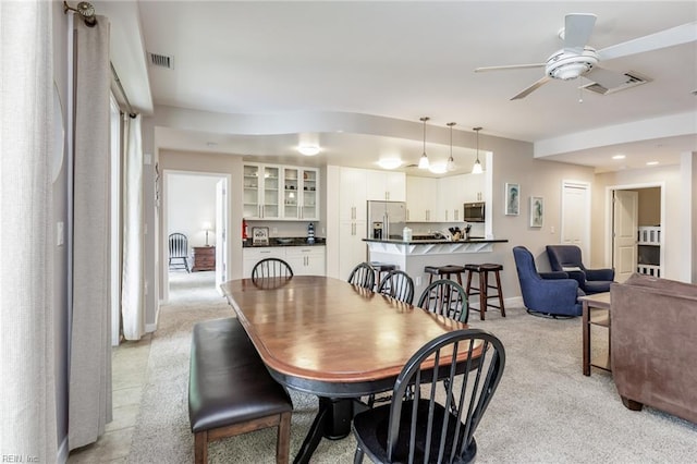 carpeted dining room with ceiling fan