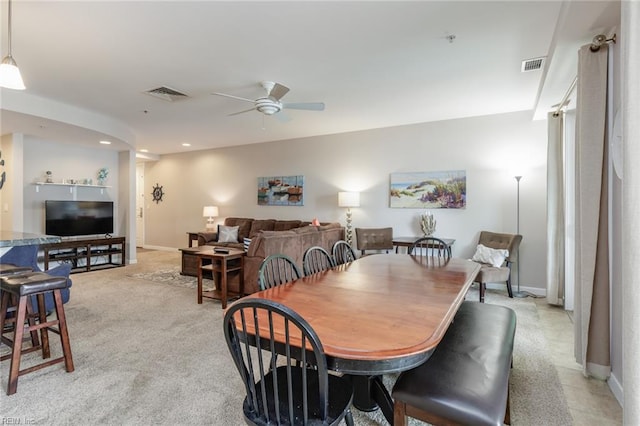 dining area with light carpet and ceiling fan