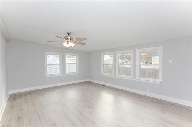 empty room with ceiling fan, a healthy amount of sunlight, and light wood-type flooring