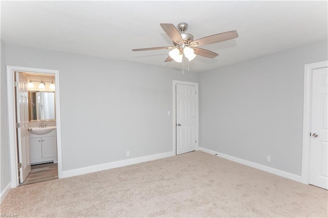 unfurnished bedroom featuring ensuite bath, ceiling fan, and light colored carpet