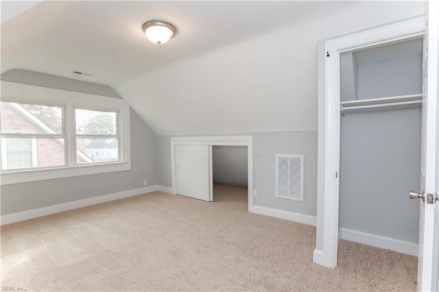 bonus room featuring light carpet and vaulted ceiling