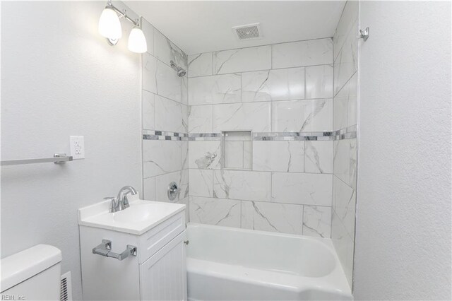 full bathroom featuring vanity, toilet, and tiled shower / bath