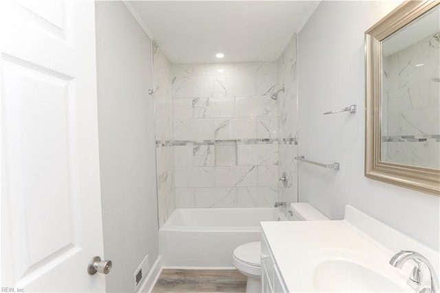 full bathroom with hardwood / wood-style flooring, vanity, toilet, and tiled shower / bath