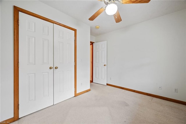 unfurnished bedroom featuring a closet, ceiling fan, and light colored carpet