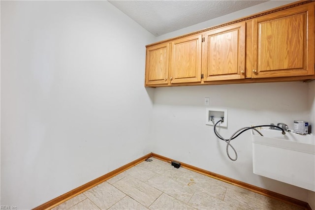 laundry area with cabinets, washer hookup, and a textured ceiling