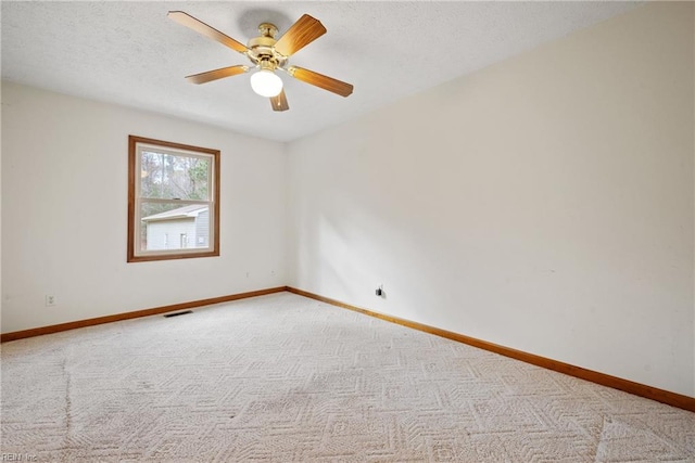 carpeted spare room featuring ceiling fan and a textured ceiling