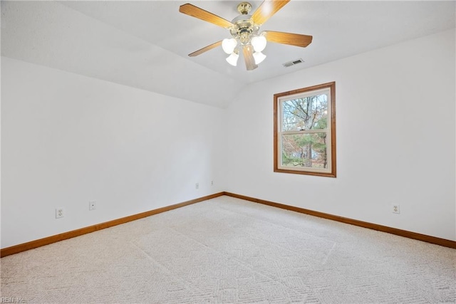 carpeted spare room featuring ceiling fan and lofted ceiling