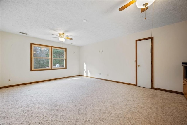 carpeted spare room featuring ceiling fan and a textured ceiling