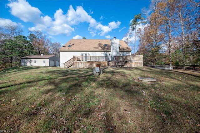 rear view of house with a lawn and a wooden deck