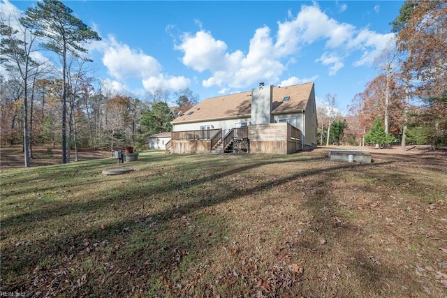 back of property featuring a lawn and a wooden deck