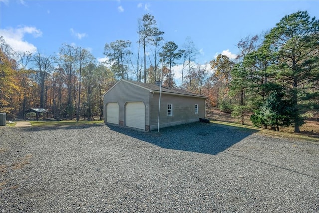 view of side of property featuring central AC unit, an outdoor structure, and a garage