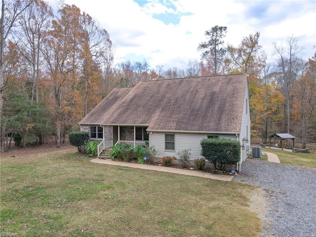 view of front facade featuring covered porch, cooling unit, and a front yard