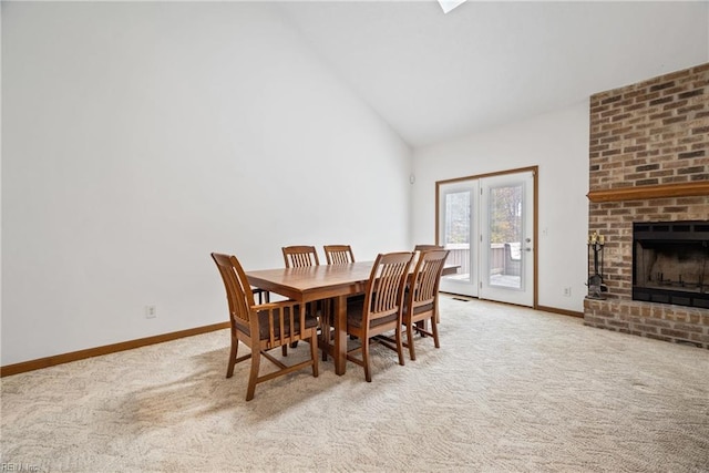 carpeted dining area featuring a brick fireplace and lofted ceiling