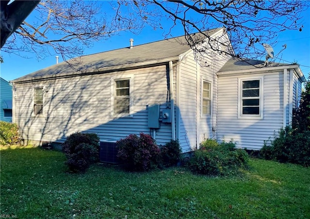 view of property exterior with cooling unit and a yard