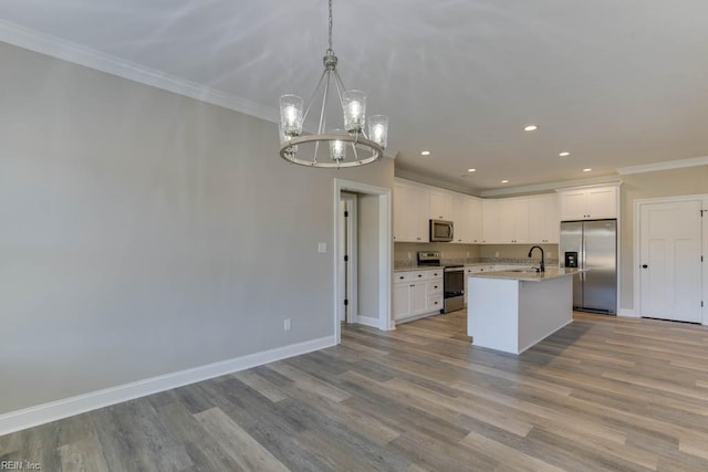 kitchen featuring white cabinetry, hanging light fixtures, light hardwood / wood-style flooring, a center island with sink, and appliances with stainless steel finishes