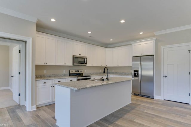 kitchen featuring sink, light stone counters, an island with sink, white cabinets, and appliances with stainless steel finishes