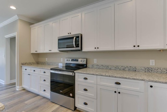 kitchen featuring light stone countertops, light wood-type flooring, ornamental molding, appliances with stainless steel finishes, and white cabinetry