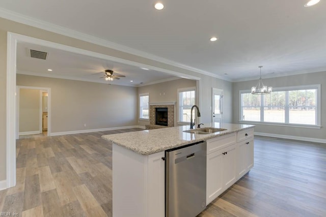 kitchen featuring white cabinets, sink, light hardwood / wood-style flooring, stainless steel dishwasher, and an island with sink