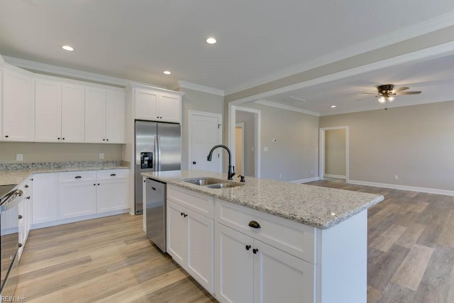 kitchen with white cabinetry, sink, ceiling fan, stainless steel appliances, and an island with sink