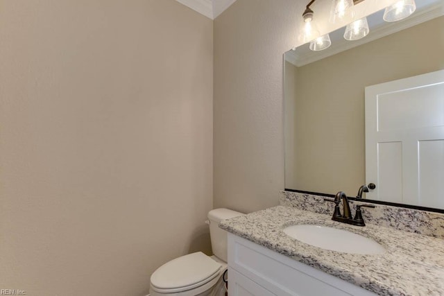 bathroom with vanity, toilet, and crown molding