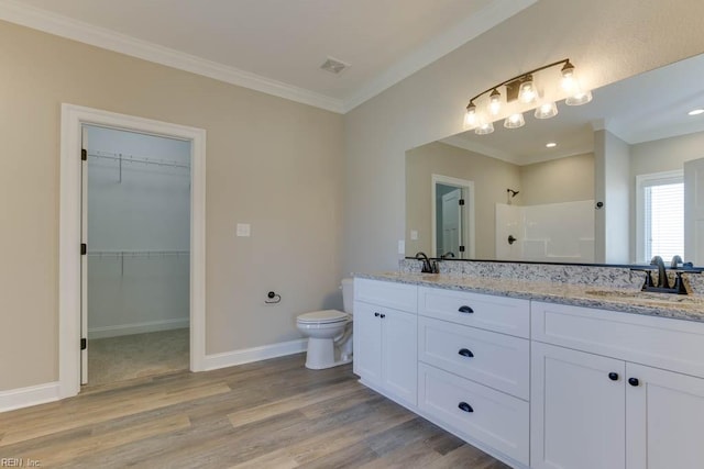 bathroom with walk in shower, vanity, crown molding, hardwood / wood-style flooring, and toilet