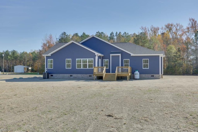 back of property featuring central air condition unit, a wooden deck, and a shed