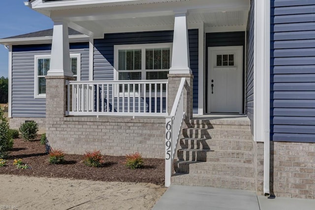 view of exterior entry with a porch