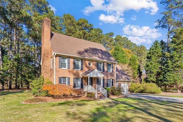 colonial home with a front yard and a garage