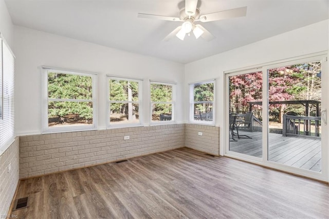 unfurnished sunroom with ceiling fan