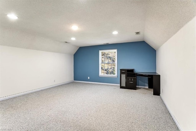 bonus room featuring a textured ceiling, light colored carpet, and lofted ceiling