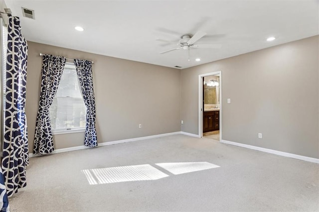 empty room featuring ceiling fan and light carpet