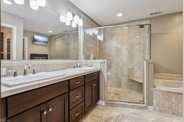 bathroom featuring vanity, shower with separate bathtub, and a skylight