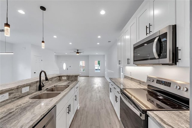 kitchen featuring white cabinets, pendant lighting, stainless steel appliances, and sink