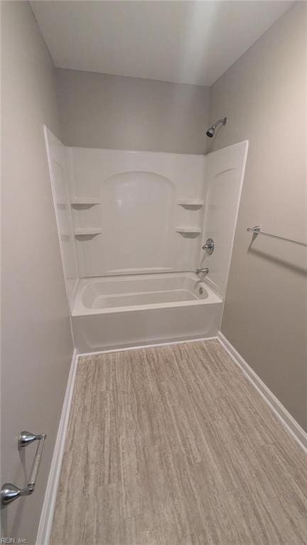 bathroom featuring wood-type flooring and bathing tub / shower combination