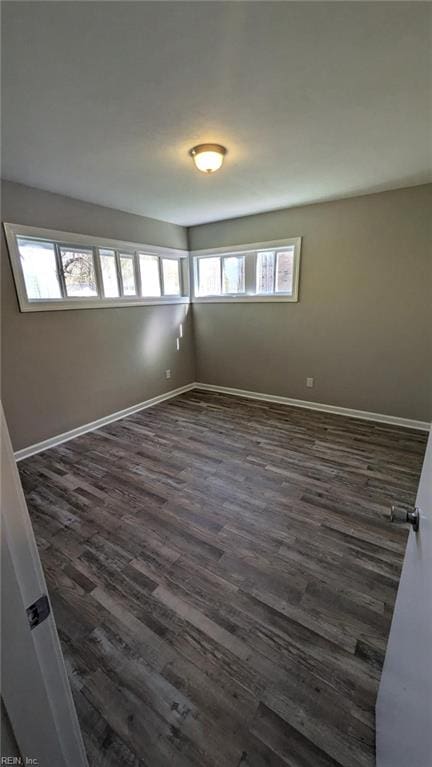 unfurnished room featuring dark hardwood / wood-style floors and a wealth of natural light