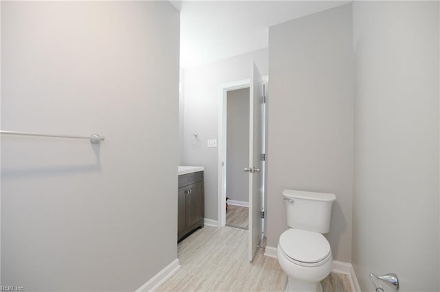 bathroom with hardwood / wood-style flooring, vanity, and toilet