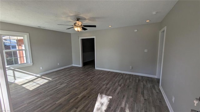 spare room featuring a textured ceiling, ceiling fan, and dark hardwood / wood-style floors