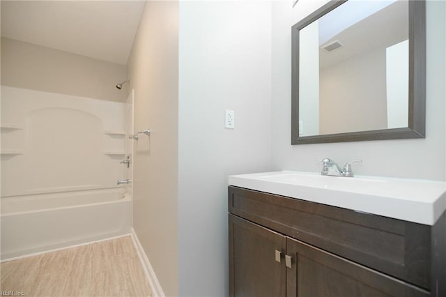 bathroom with bathing tub / shower combination, vanity, and hardwood / wood-style flooring