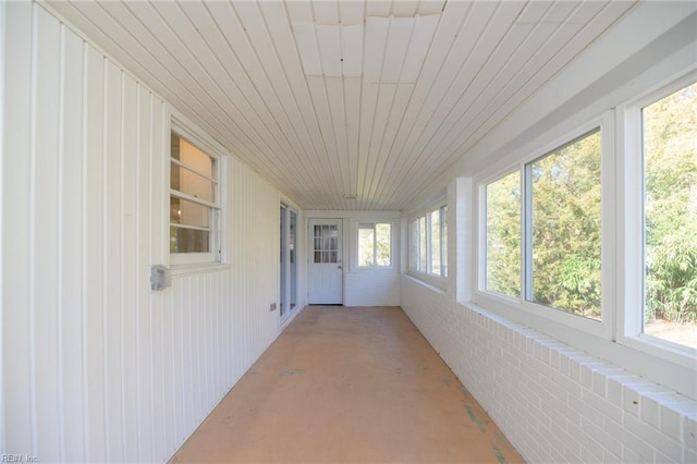 unfurnished sunroom with wood ceiling and a healthy amount of sunlight