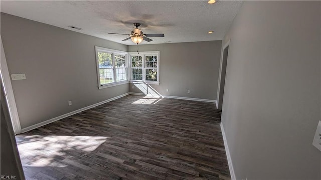 empty room with a textured ceiling, ceiling fan, and dark wood-type flooring