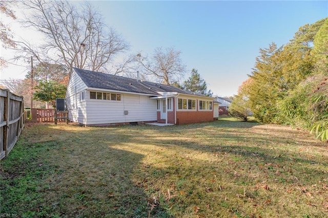 rear view of house featuring a lawn