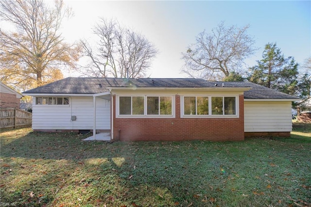 rear view of house featuring a lawn