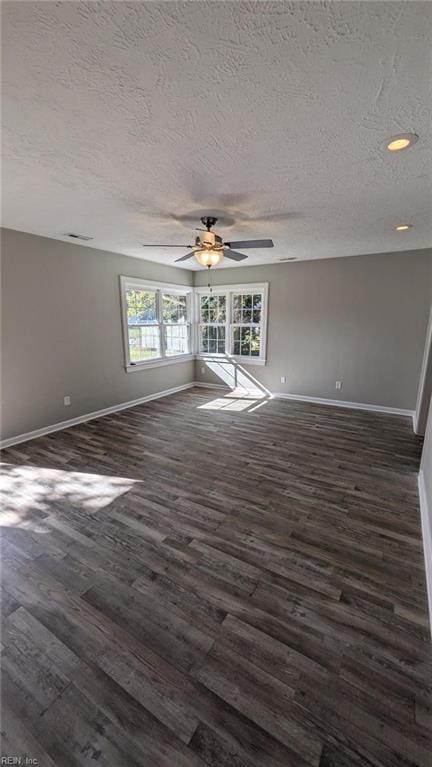 spare room featuring ceiling fan, dark wood-type flooring, and a textured ceiling