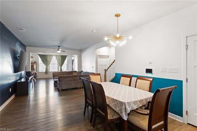 dining space with dark hardwood / wood-style flooring and ceiling fan with notable chandelier